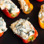 Spinach and Cheese Stuffed Peppers are a super easy party pleaser. No need to worry about spice, these easy stuffed peppers use sweet peppers, cream cheese and spinach to create awesome finger food great for any occasion.