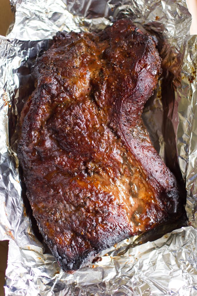 Savory brisket slow smoked on the grill, Texas style! All you need is salt, pepper and a big ol' hunk of meat.