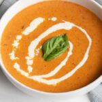 With red peppers, tomatoes, garlic and fresh herbs, this easy, creamy roasted red pepper and tomato soup is my favorite way to warm up on a cold day.