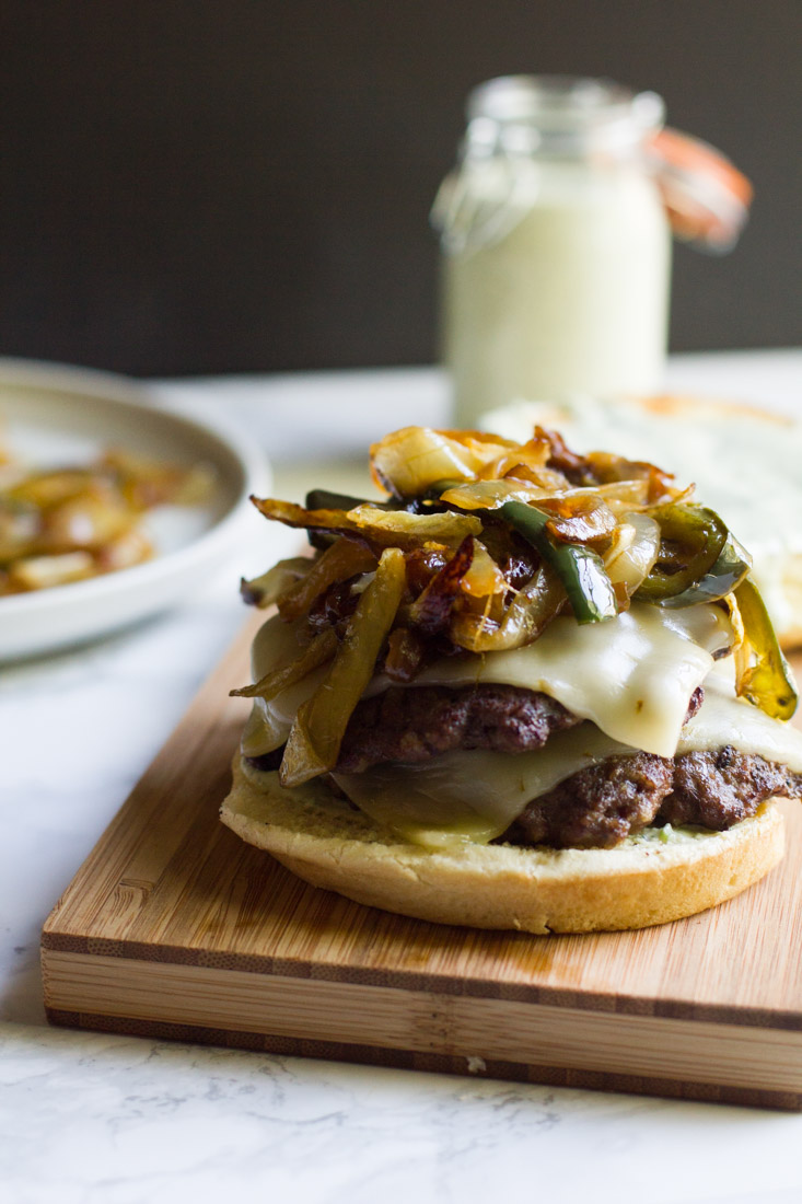 A copycat recipe of a fast food favorite: the Monterey Melt. It's a juicy burger piled high with cheese, grilled peppers and onions and jalapeno ranch.