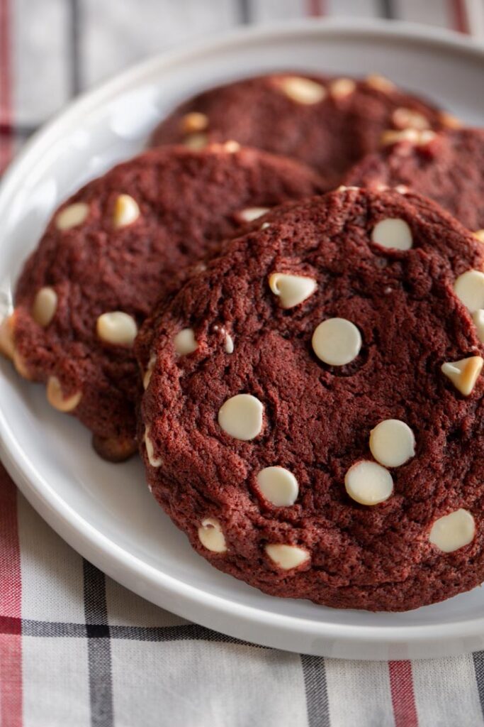 red velvet cookies with white chocolate chips on a plate on top of a towel
