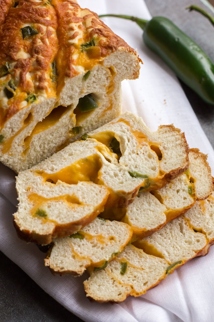 three slices of jalapeno cheese bread falling from the loaf