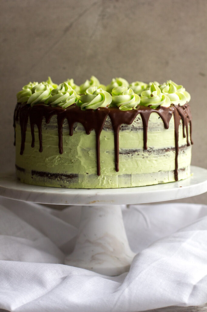 a mint julep cake, chocolate bourbon cake with mint frosting, sitting on a white cake stand