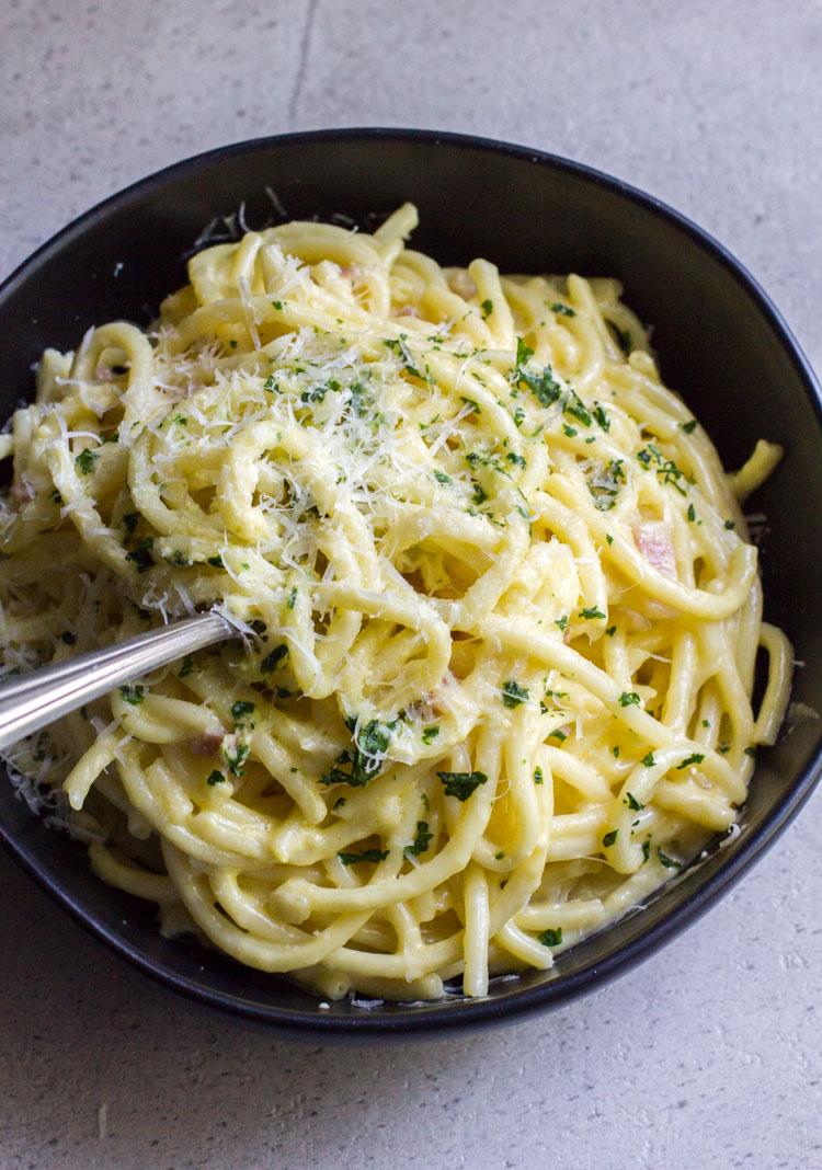creamy pancetta carbonara in a black bowl
