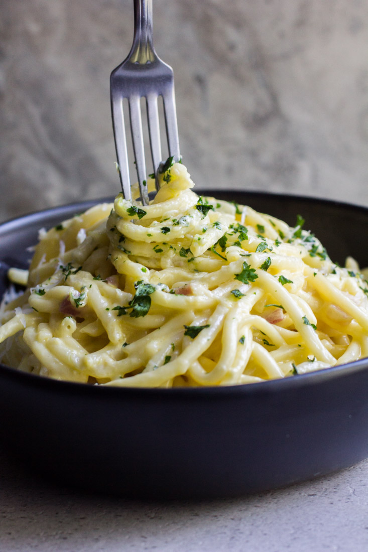 creamy pancetta carbonara in a bowl with a fork ready to eat