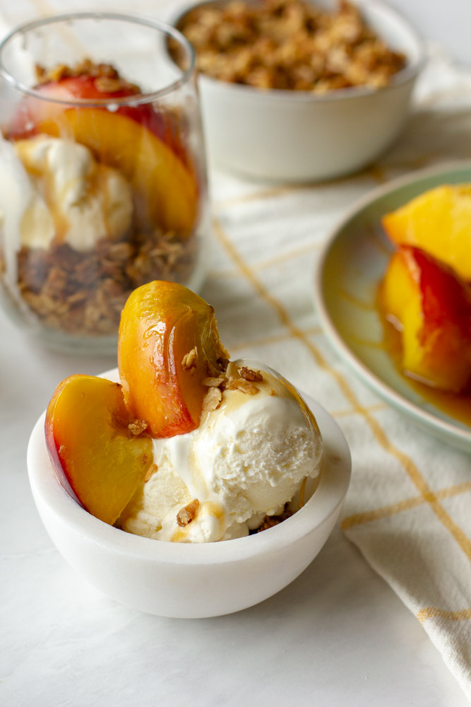 peach sundae on a table with ice cream, honey and oats