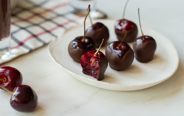 wine soaked chocolate covered cherries on a plate