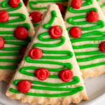 A simple, easy-to-make shortbread cookie recipe shaped and iced to make super cute Christmas Tree cookies! Crispy, flaky, sweet cookies that hold their shape when baking! #ChristmasCookies #HolidayBaking #ShortbreadCookie