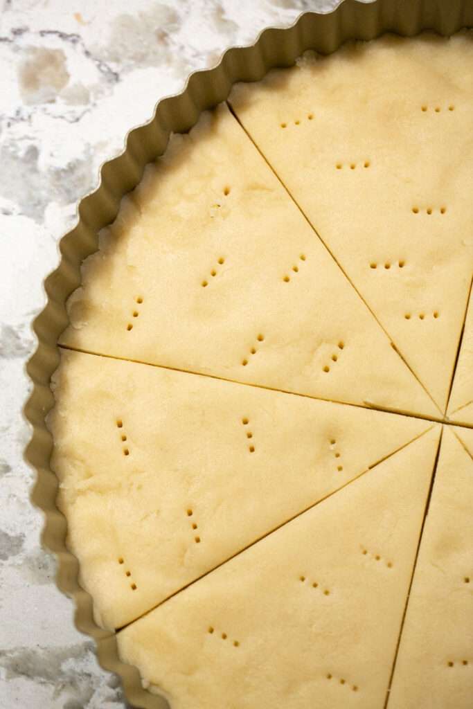 christmas tree cookie dough pressed into a tart pan prior to baking
