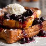 stuffed french toast with blueberry sauce and whipped cream on top