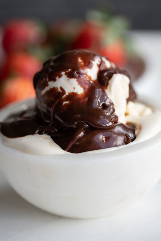 hot fudge sauce on top of ice cream in a bowl