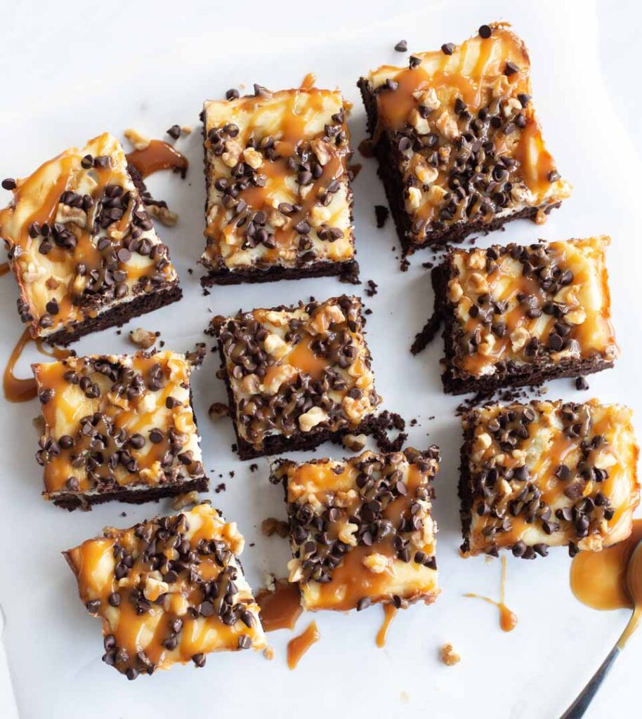 turtle cheesecake brownies with caramel and chocolate cut into squares