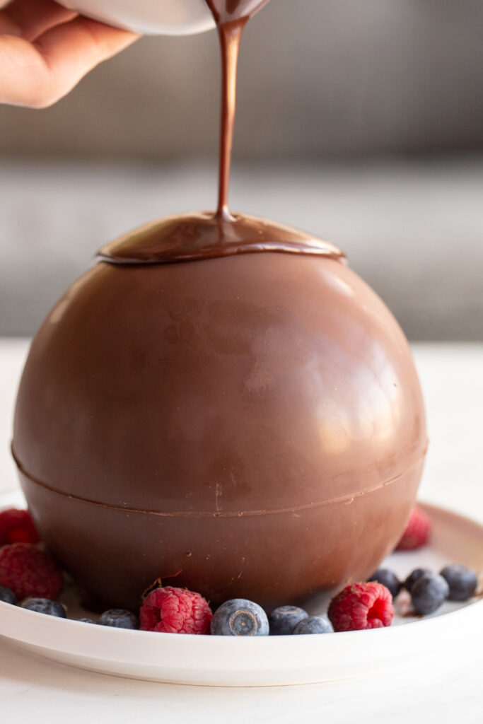 chocolate ball dessert with hot fudge being poured on top