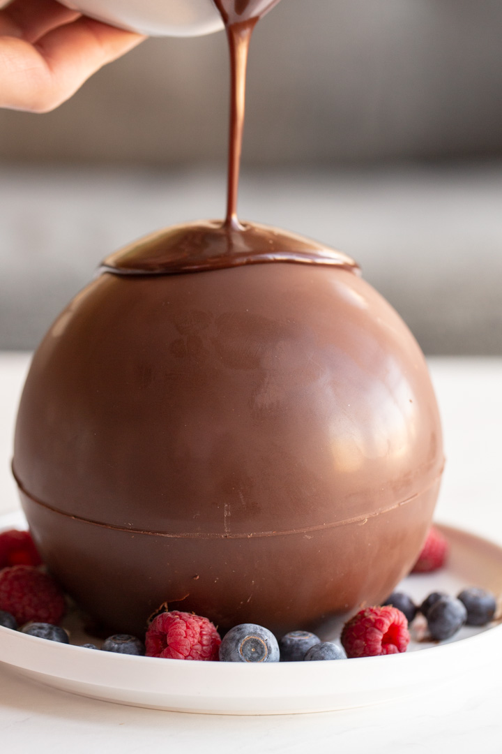 chocolate ball dessert with hot fudge being poured on top