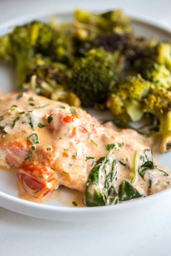 pan seared salmon with spinach and tomatoes on a plate