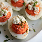 This recipe for buffalo deviled eggs has a spicy, tangy buffalo filling and blue cheese topping. It's great for serving at Easter, Independence Day, on game night or just to share with family and friends!