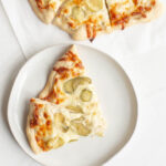 Creamy garlic sauce, dill pickles and cheese make this amazing dill pickle pizza. Don't knock it 'til you try it - it's garlicky and delicious!