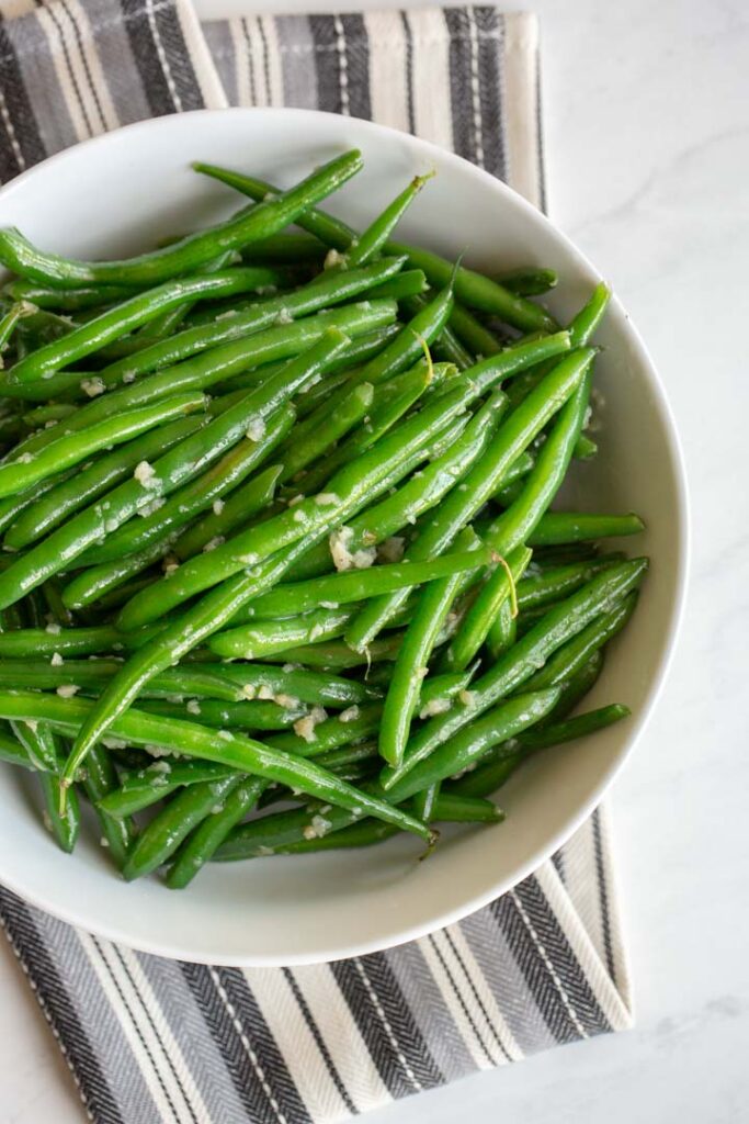 garlic green beans in a bowl on a towel