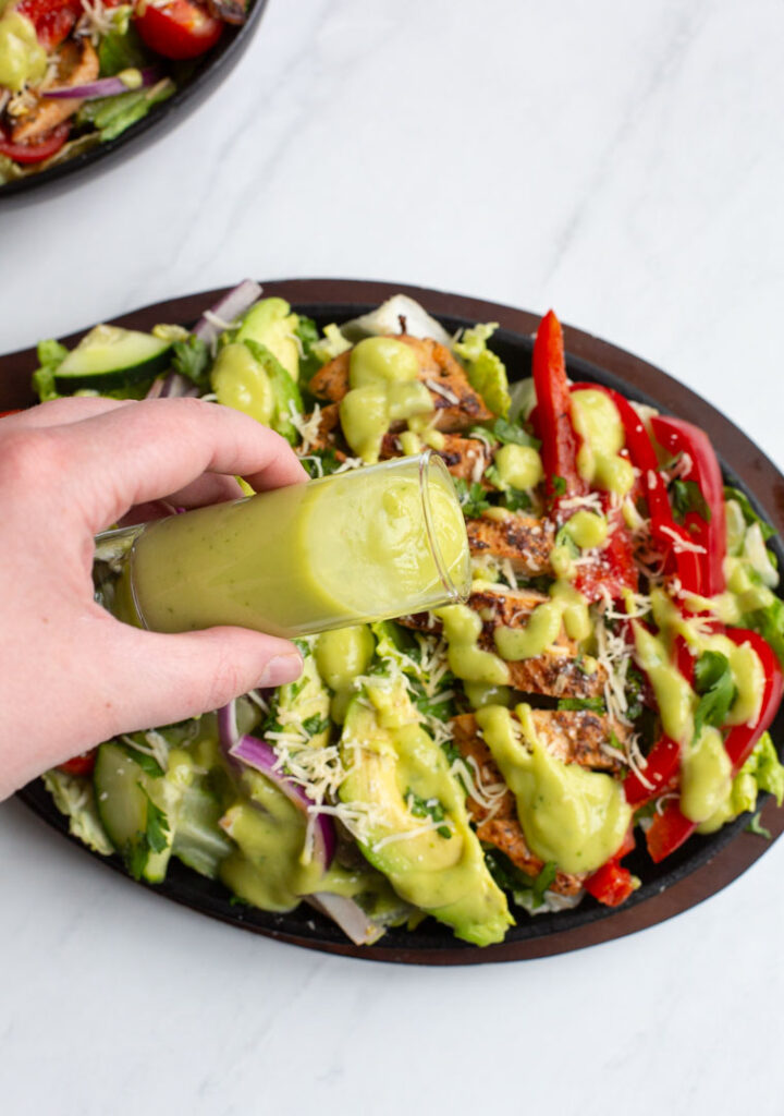 fajita chicken salad on a plate topped with avocado lime dressing