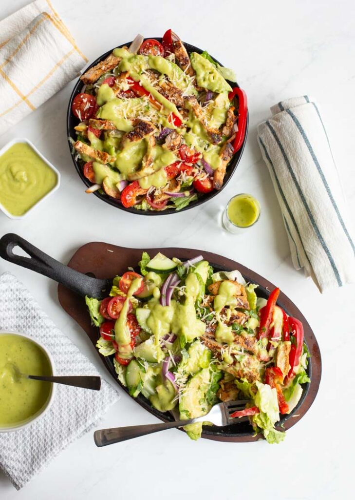 fajita chicken salad with tomatoes, onions and peppers topped with avocado lime dressing