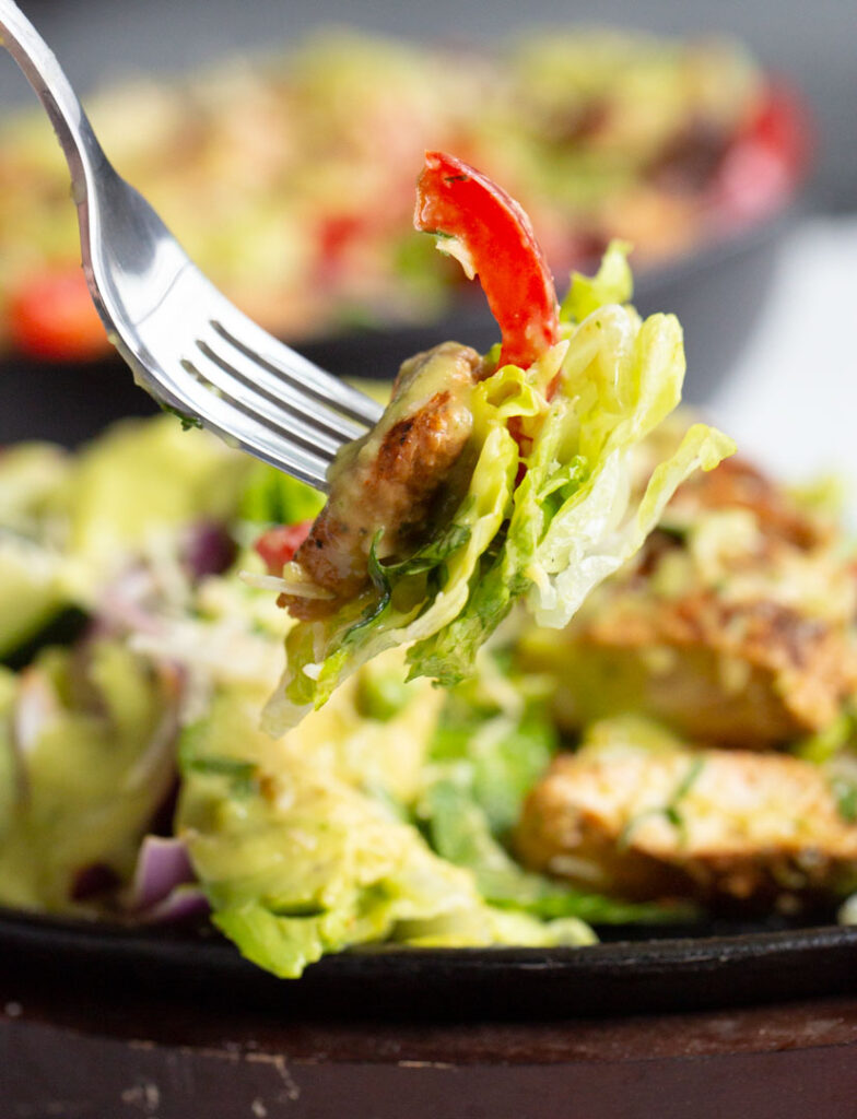 a fork holding a bite of fajita chicken salad
