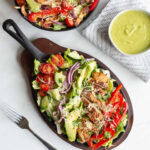 This fajita chicken salad is a mix of grilled fajita chicken, peppers, onions, tomatoes and more laid atop a bed of romaine lettuce and topped with a bright and refreshing avocado lime dressing. 