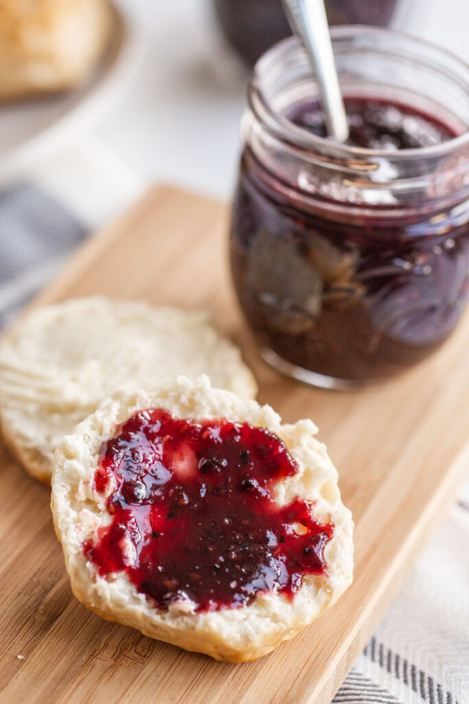 mixed berry jam spread of a biscuit with butter