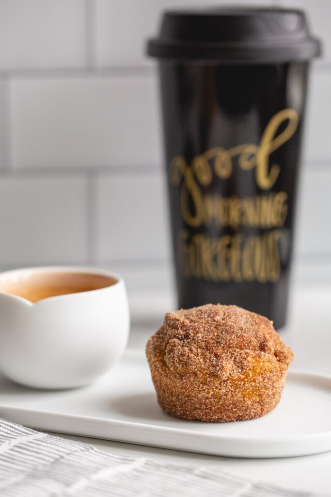 one pumpkin muffin on a plate with a shot of espresso