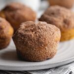 Super easy pumpkin muffins baked and rolled in cinnamon sugar. Perfectly paired with a morning coffee, they're soft, dense, and bursting with flavor!