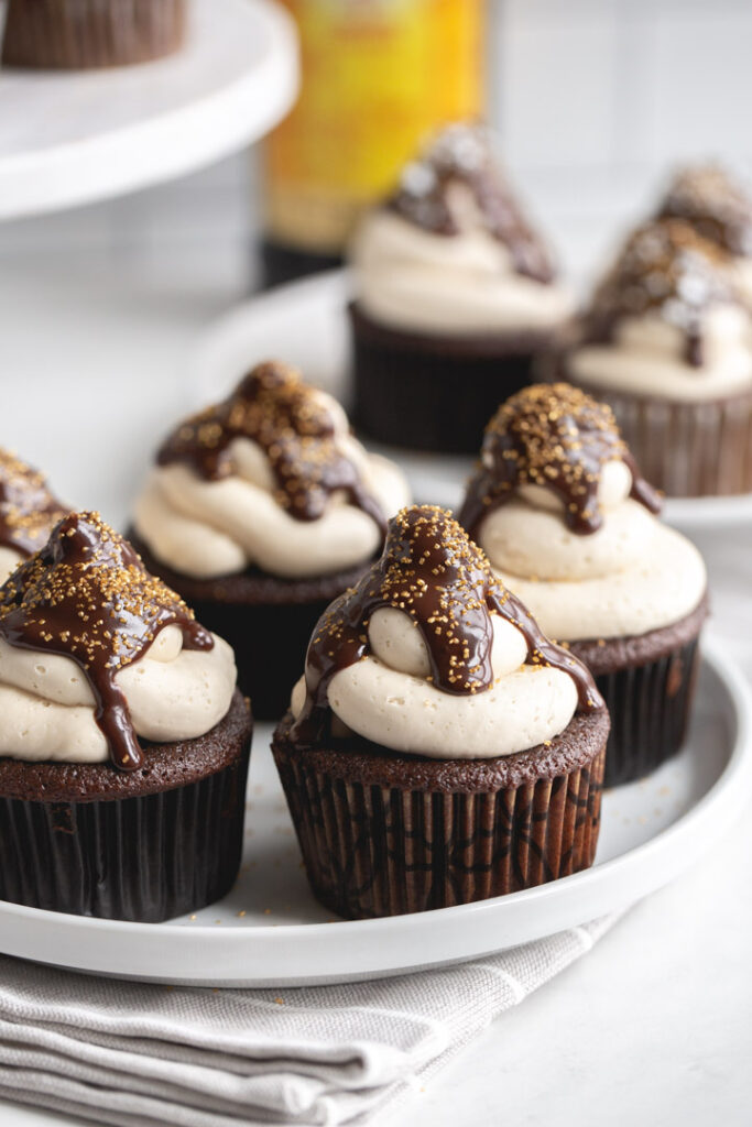 kahlua cupcakes on a plate with frosting and chocolate ganache and sprinkles