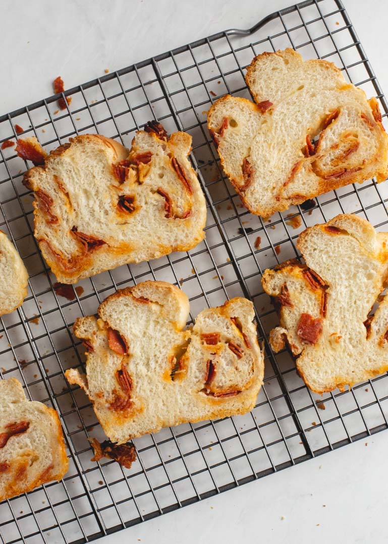 slices of pizza bread on a wire rack with cheese and pepperoni